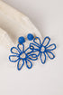 Blue flower-shaped earrings on a light background
