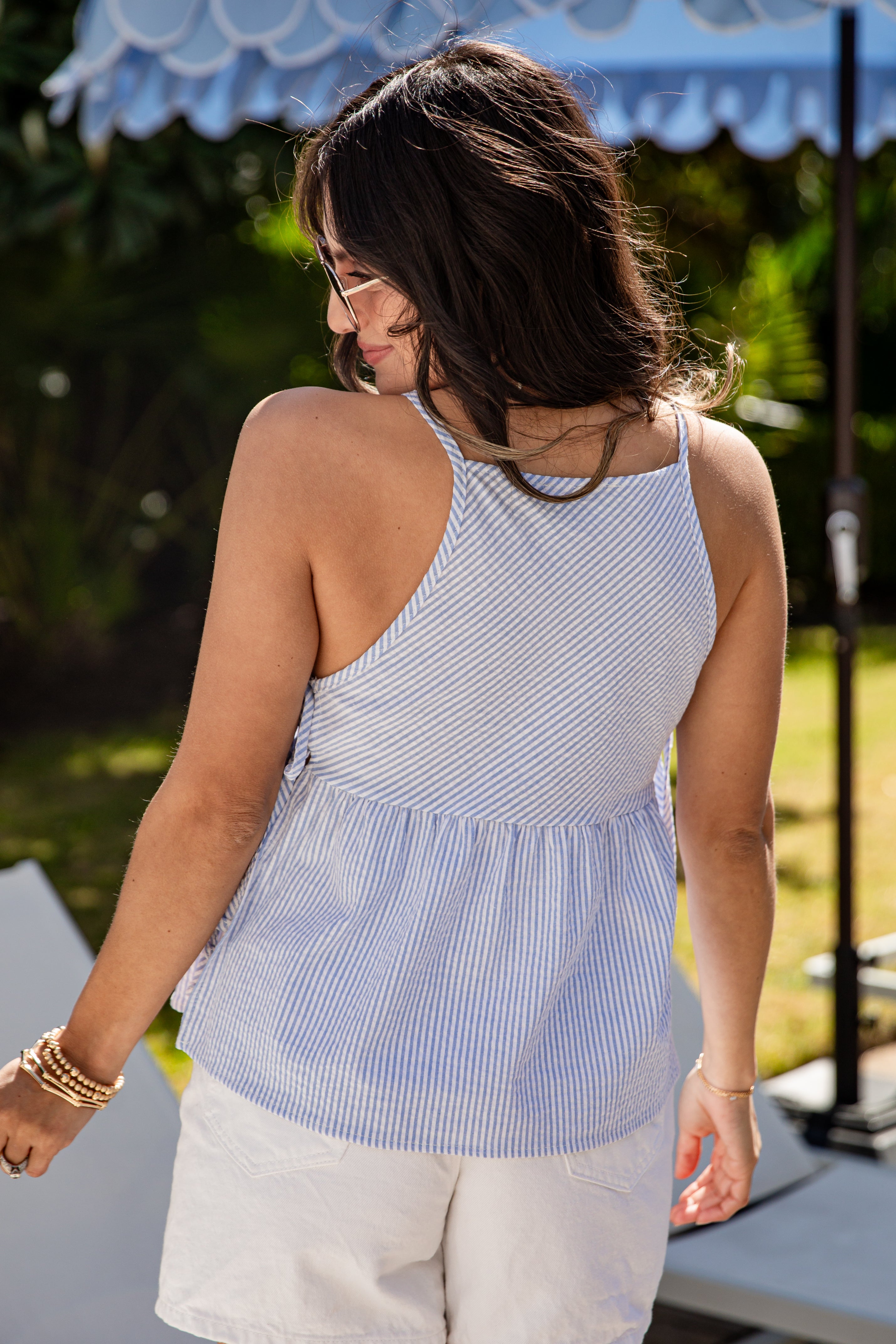 Woman wearing a blue and white striped sleeveless top outdoors