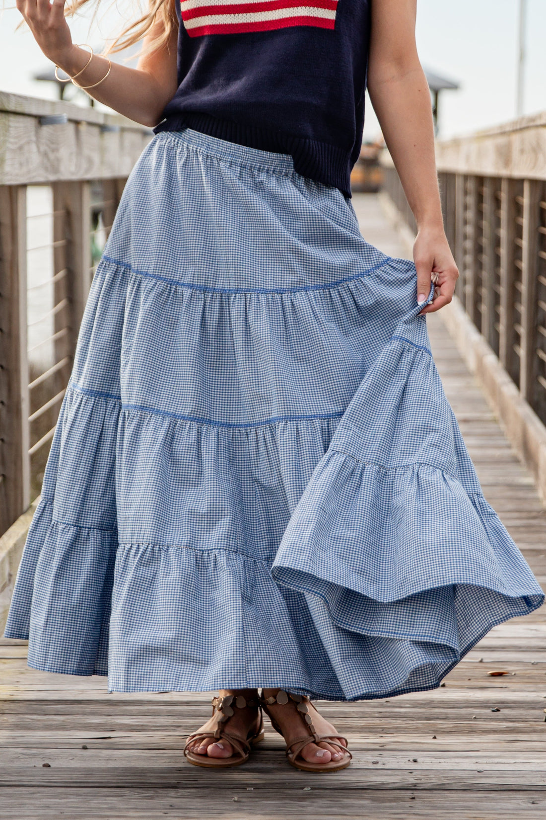 Person wearing a blue tiered skirt on a wooden deck