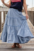 Person wearing a blue tiered skirt on a wooden deck