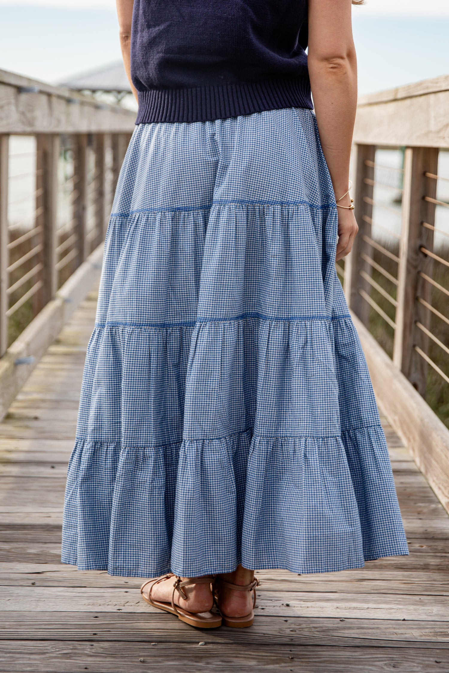 Person wearing a blue tiered skirt on a wooden deck