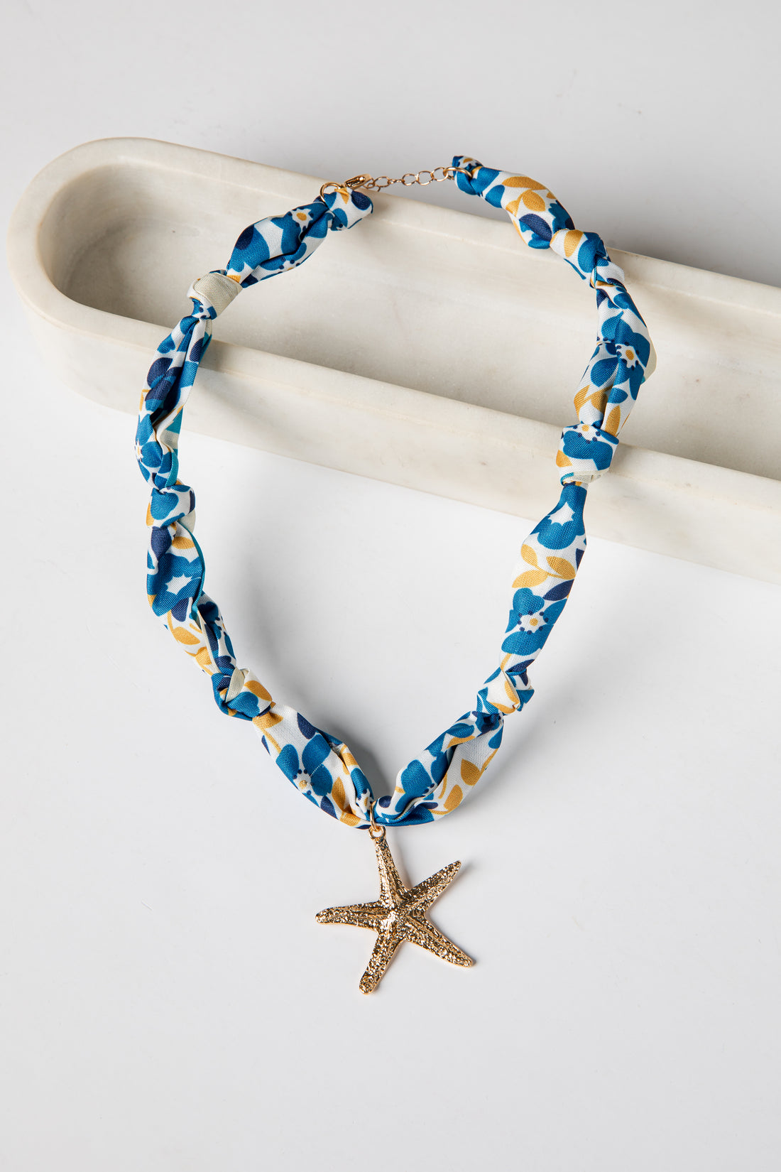 Necklace with starfish charm on a white surface