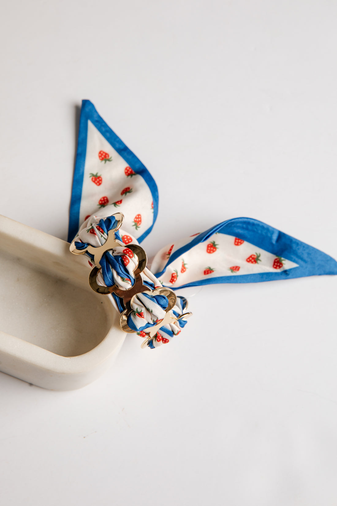 Decorative bow with blue ribbon and strawberry pattern on a white background