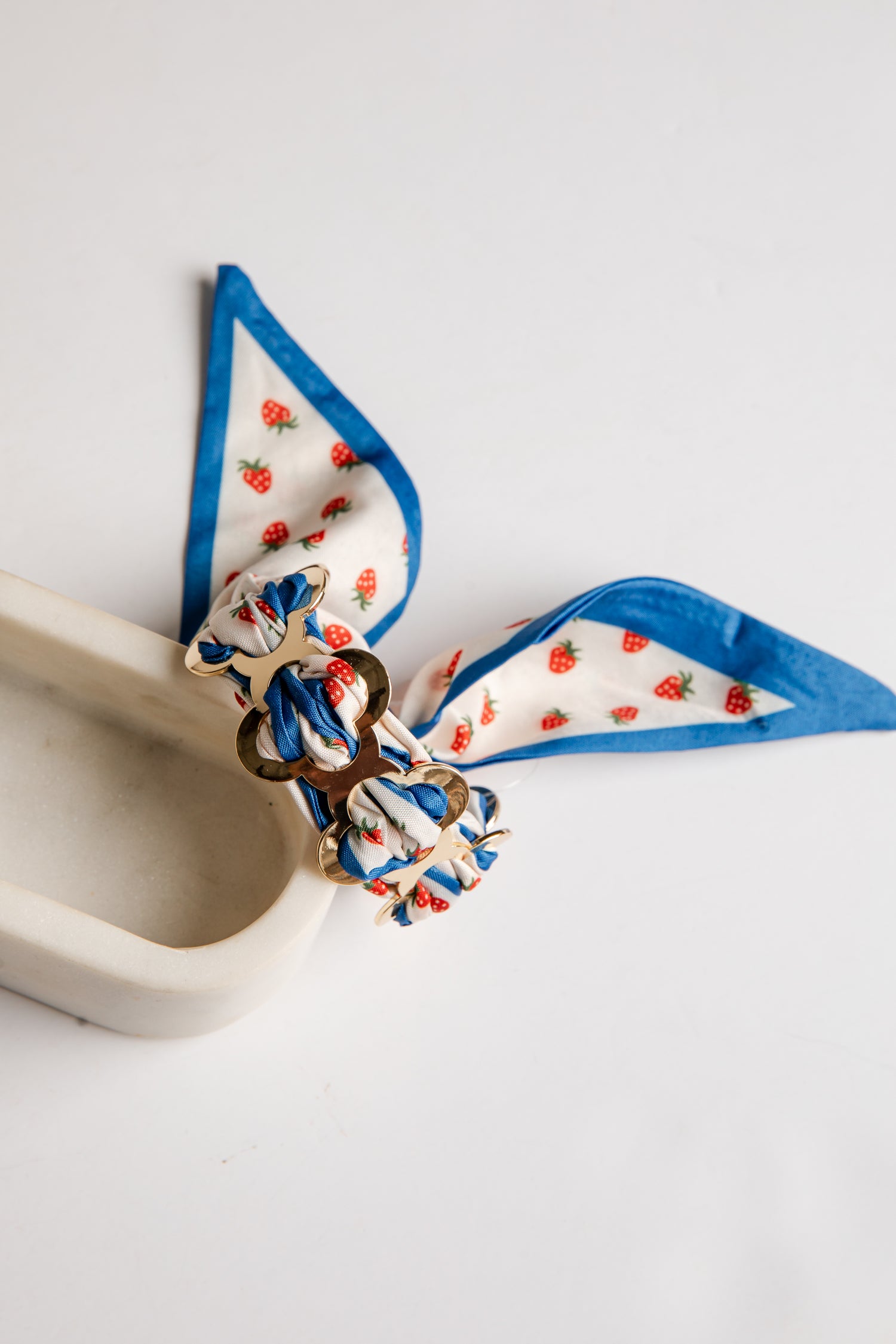Decorative bow with blue ribbon and strawberry pattern on a white background