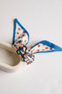 Decorative bow with blue ribbon and strawberry pattern on a white background