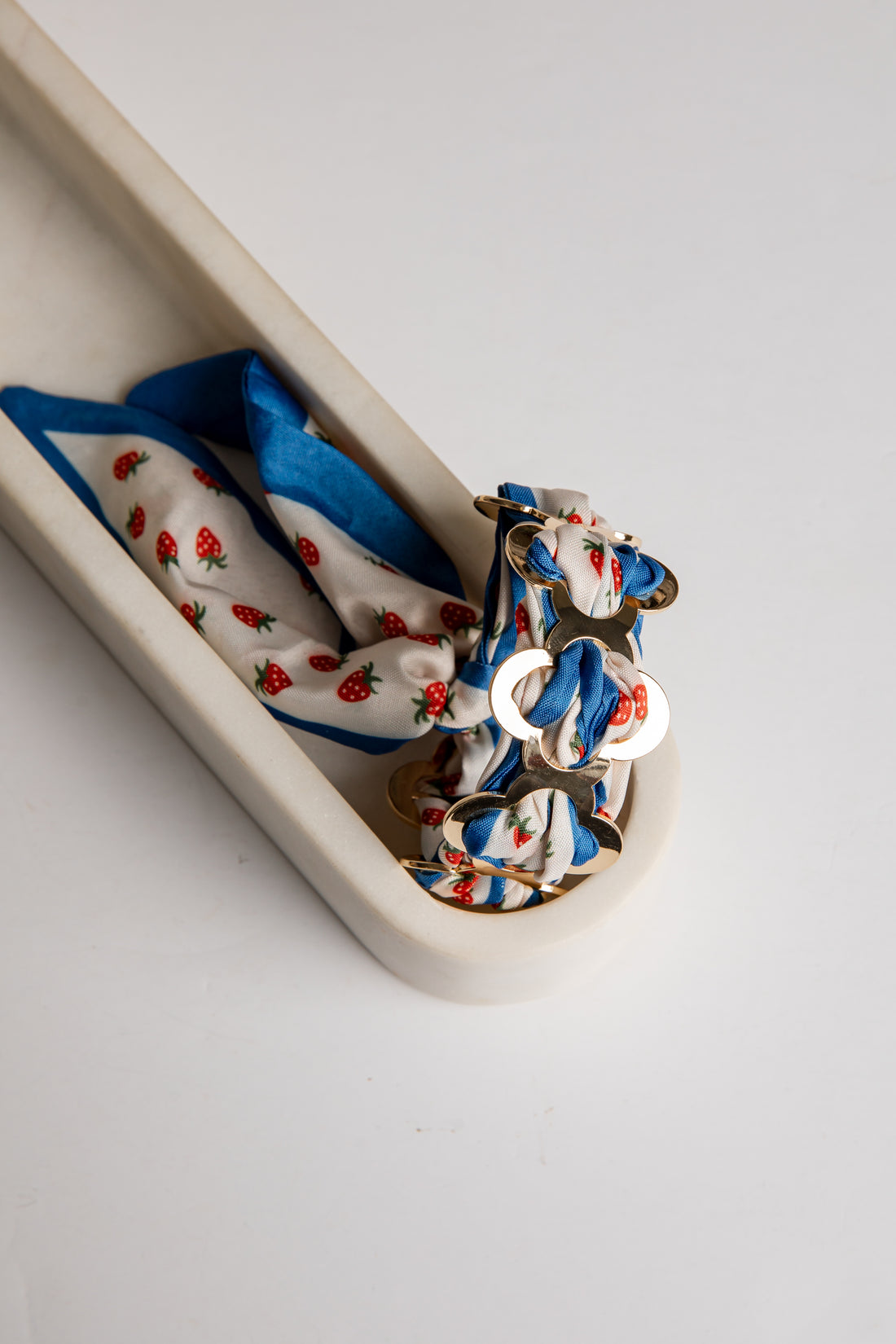 Set of colorful bracelet with strawberry pattern on a white tray