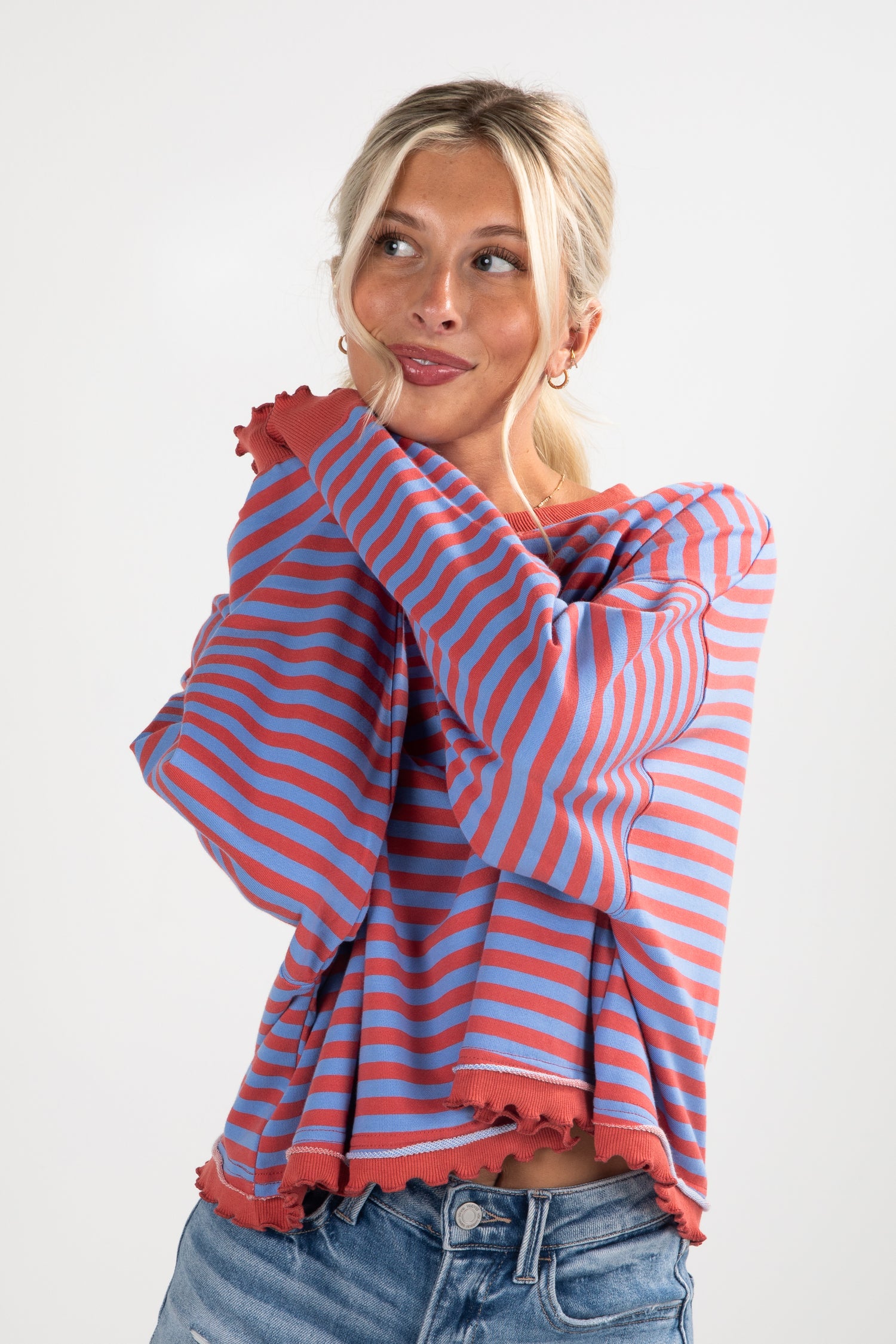 Woman wearing a red and blue striped sweater against a white background