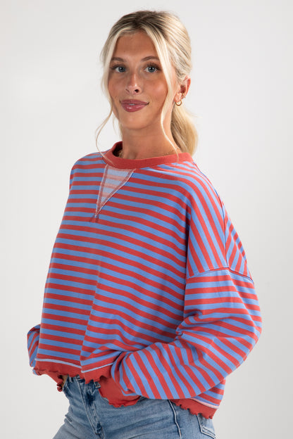 Woman wearing a red and blue striped sweater against a white background