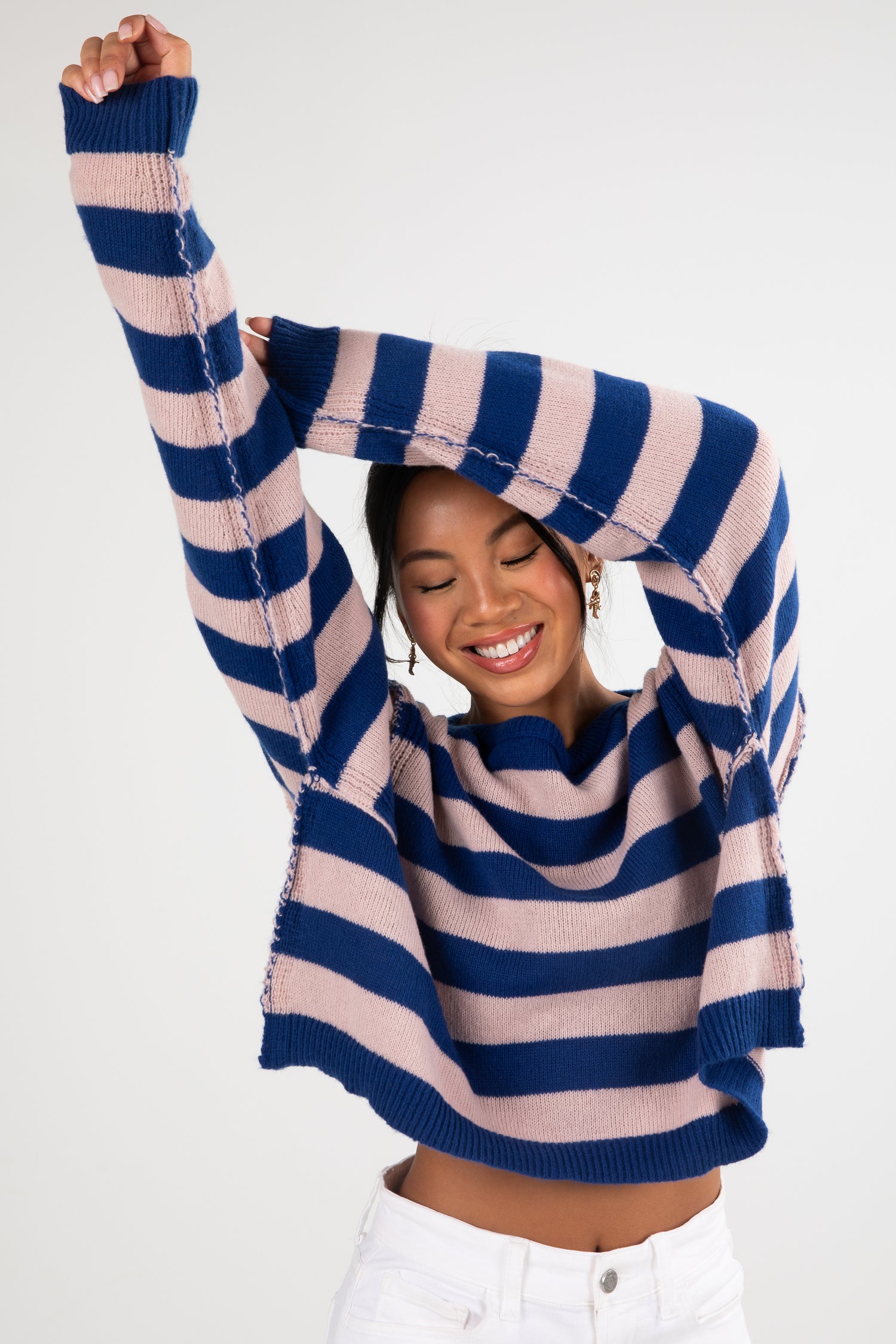 Person wearing a blue and pink striped sweater on a white background
