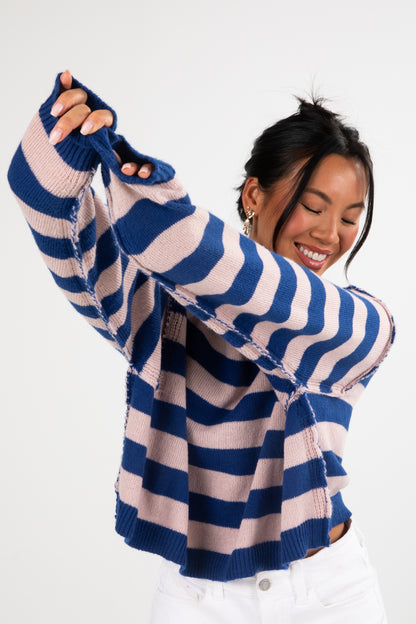 Person wearing a blue and white striped sweater on a white background