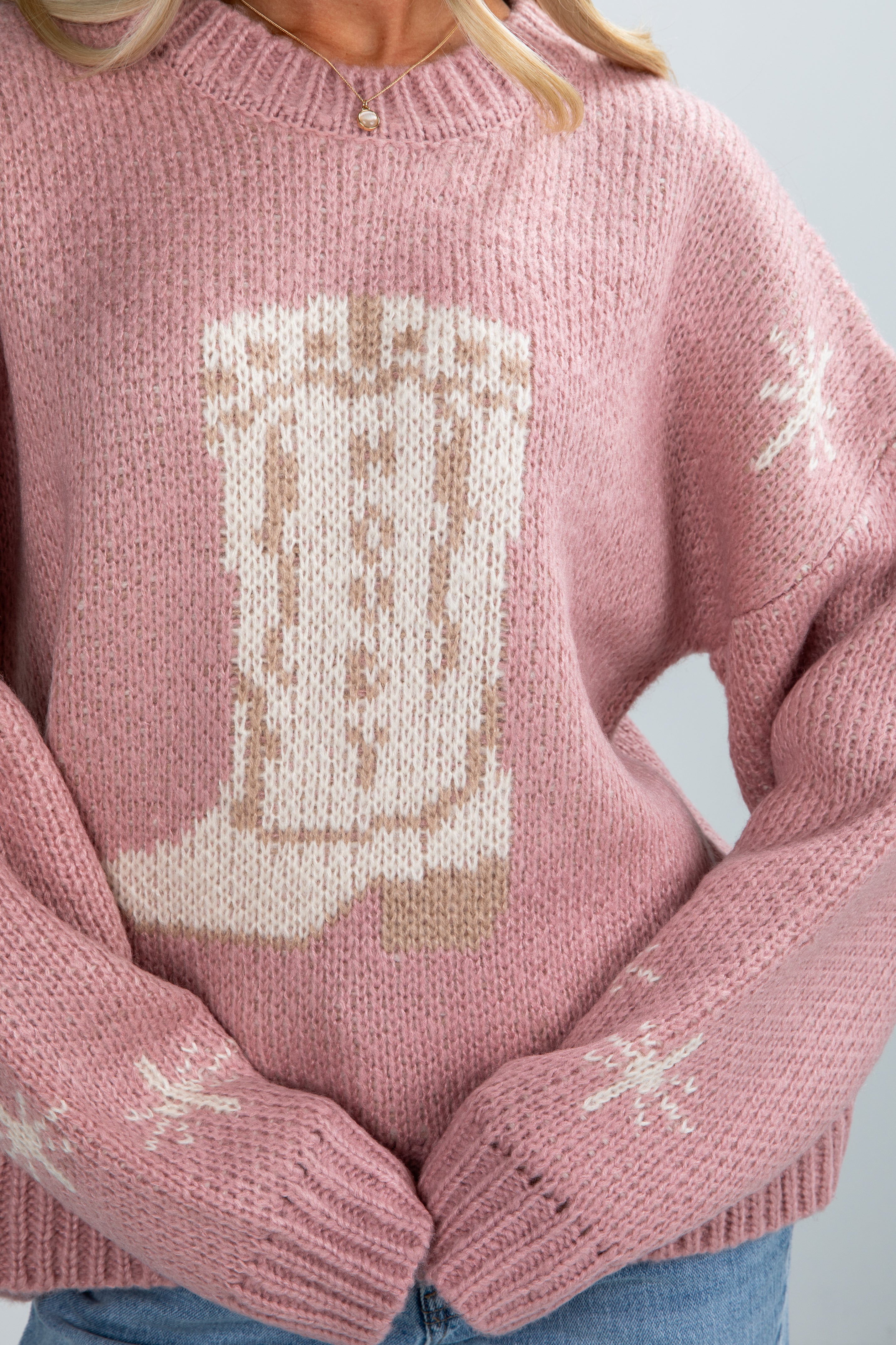 Pink sweater with a cat design on a light gray background