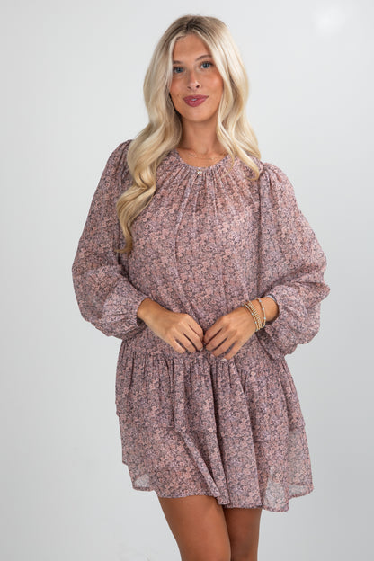 Woman wearing a pink floral dress against a white background