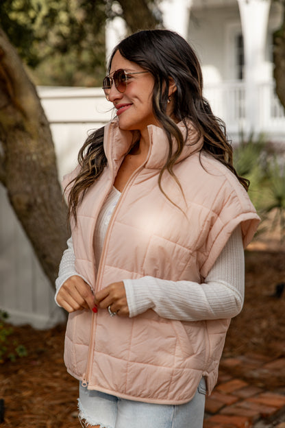 Woman wearing a pink puffer vest outdoors