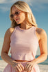 Woman in a pink dress holding a straw bag on a beach