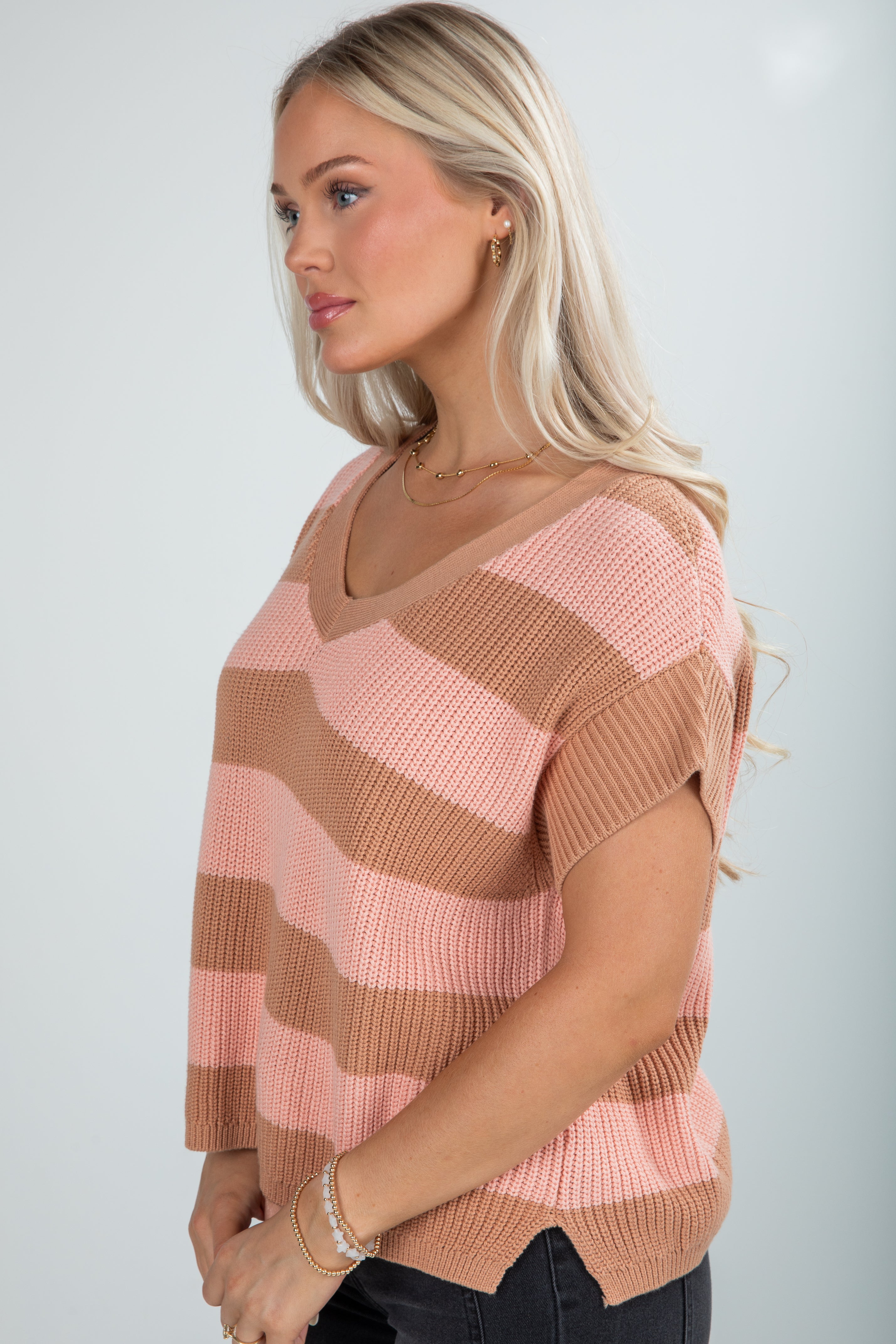 Woman wearing a striped sweater with a neutral background