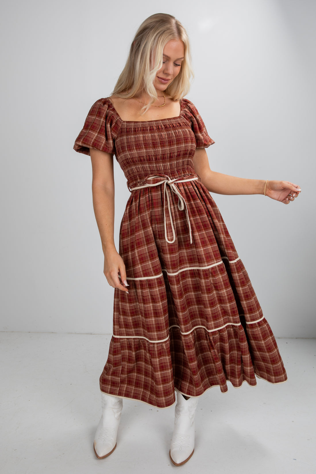 Woman wearing a plaid dress with a plain background