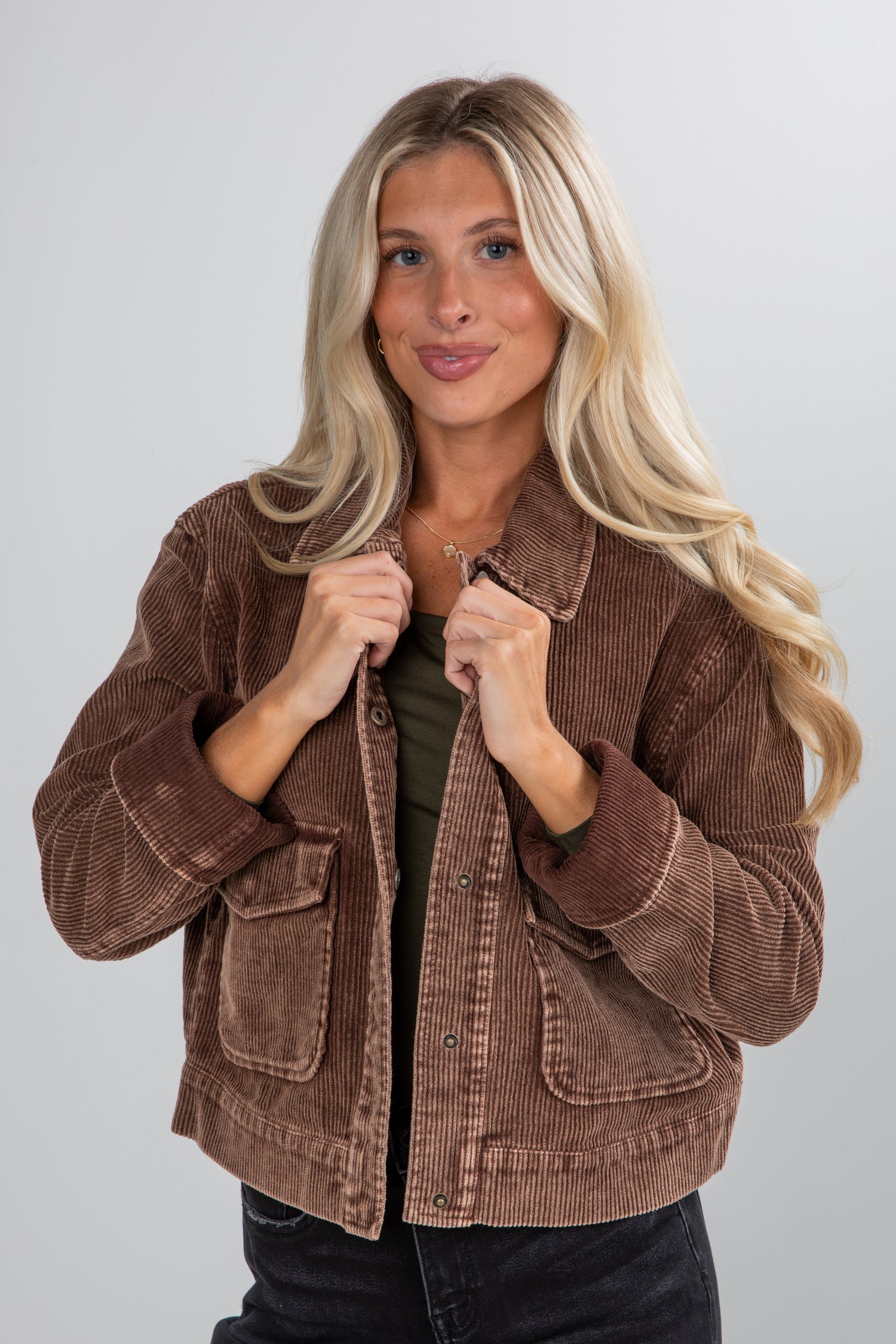 Woman wearing a brown jacket on a gray background