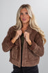 Woman wearing a brown jacket on a gray background