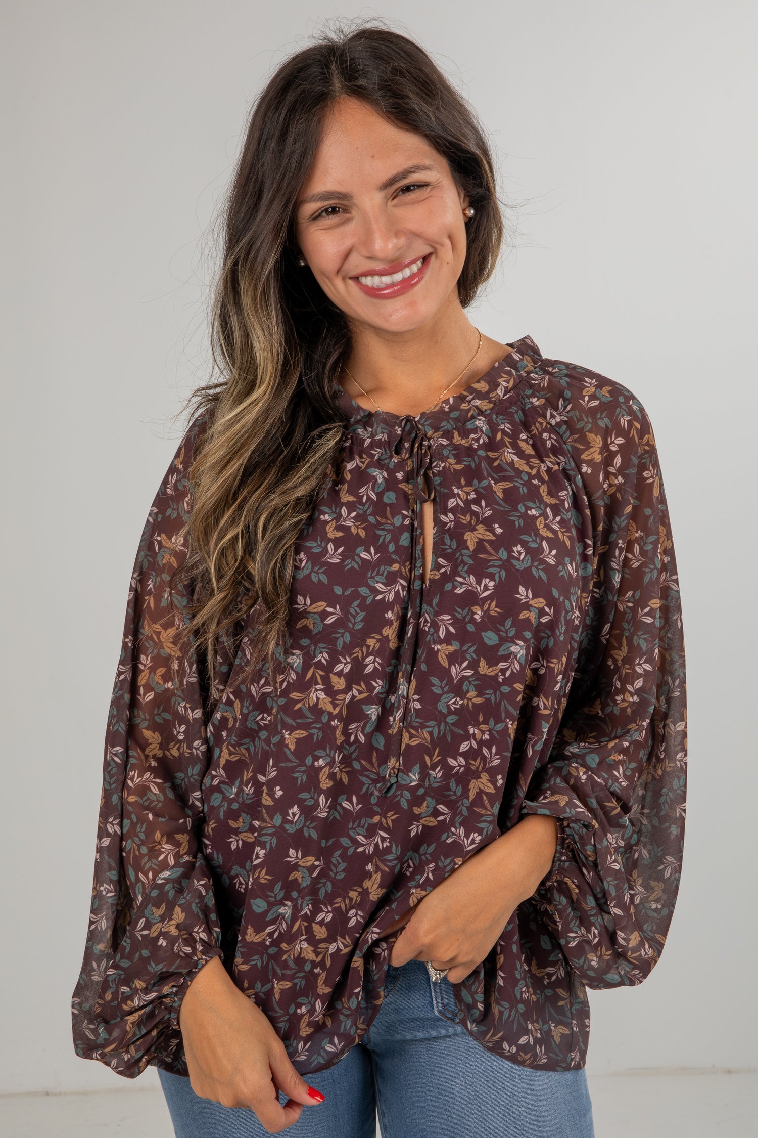 Woman wearing a floral blouse with a plain background
