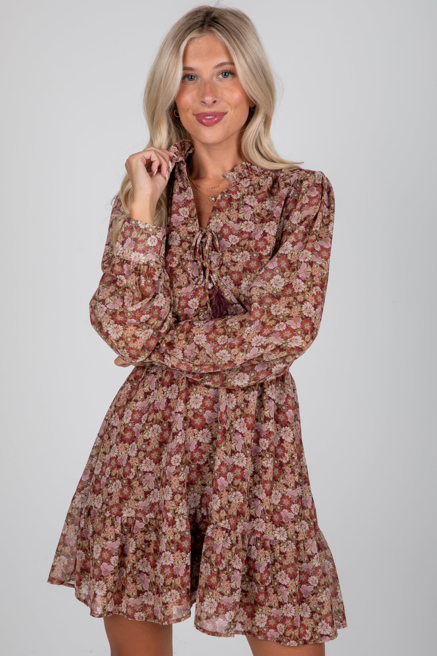 Woman wearing a floral dress against a plain background