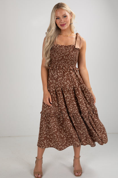 Woman wearing a brown floral dress on a white background