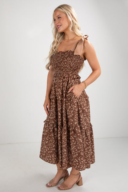 Woman wearing a brown floral dress on a white background