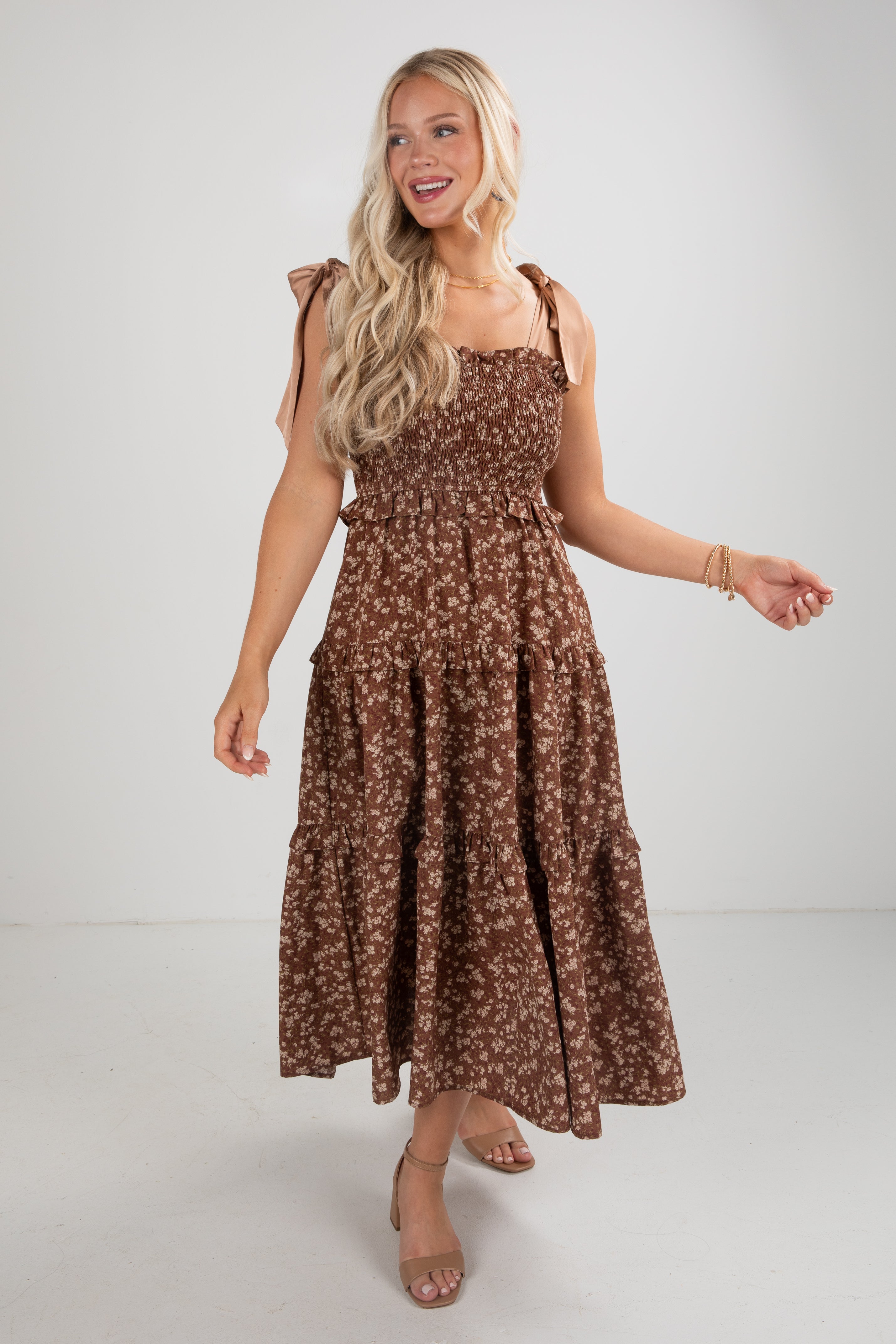 Woman wearing a brown floral dress on a white background