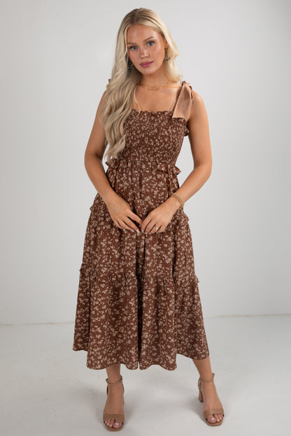 Woman wearing a brown floral dress against a white background