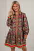 A woman models a brown long-sleeve mini shirt dress with a pink and green floral pattern, featuring a green collar, pink and green trim, and a button-up front.