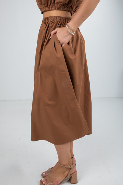 Brown skirt worn by a person on a white background