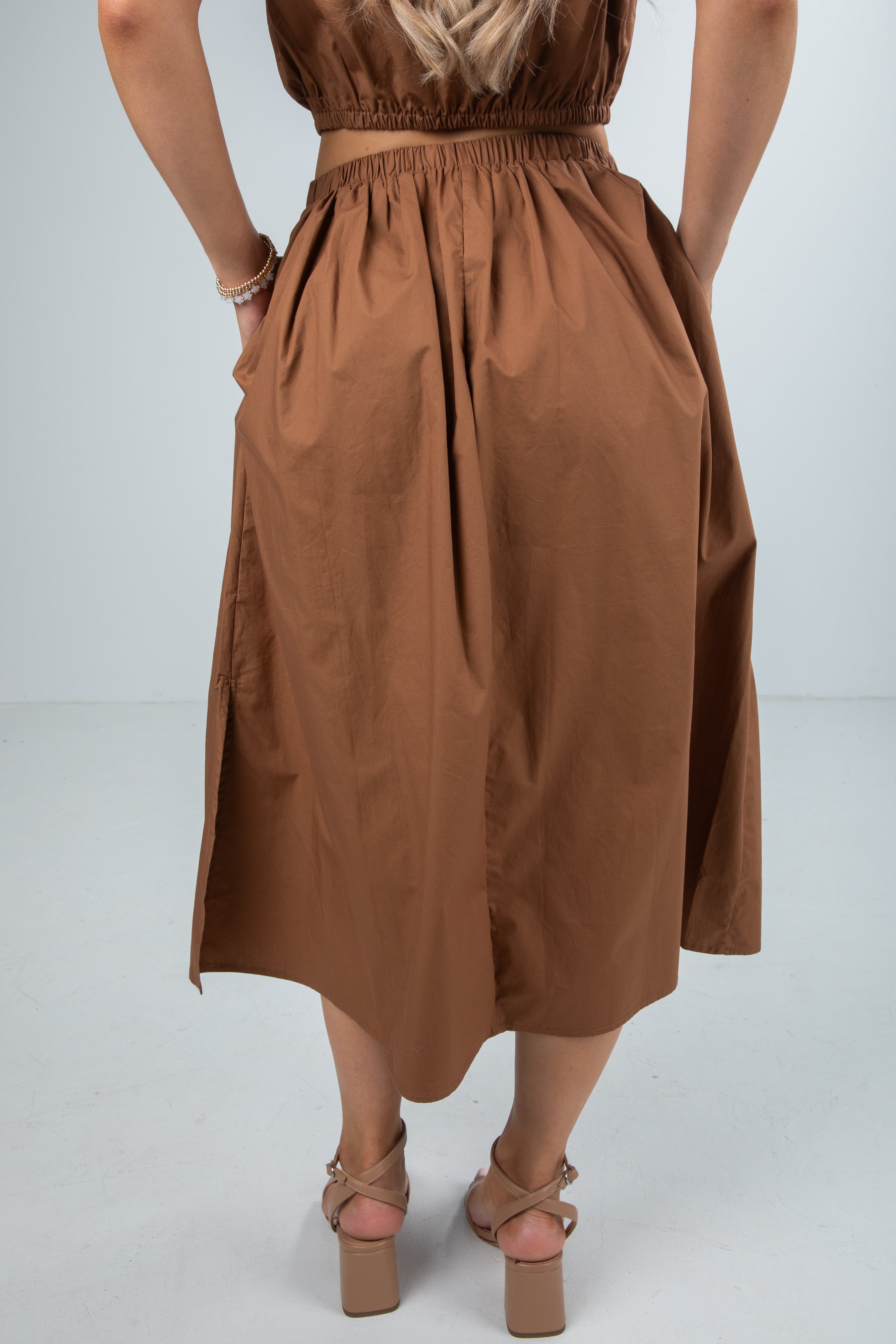 Brown dress worn by a person on a white background