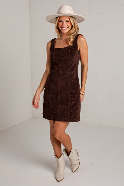 corduroy brown mini dress styled with a fedora hat and cowgirl boots