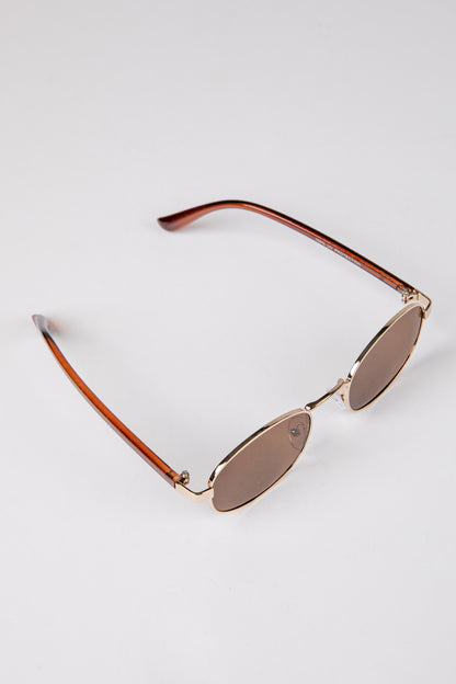 Sunglasses with gold frame and brown lenses on a white background