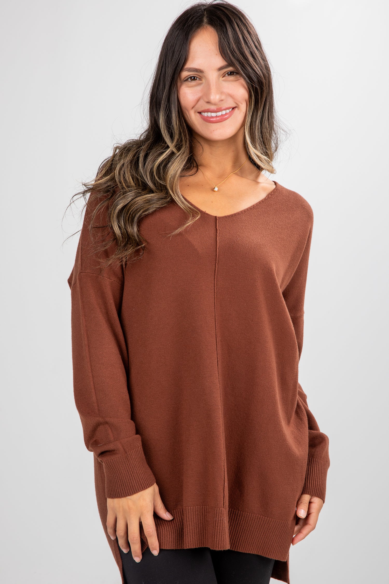 Woman wearing a brown sweater against a white background