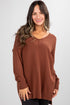 Woman wearing a brown sweater against a white background