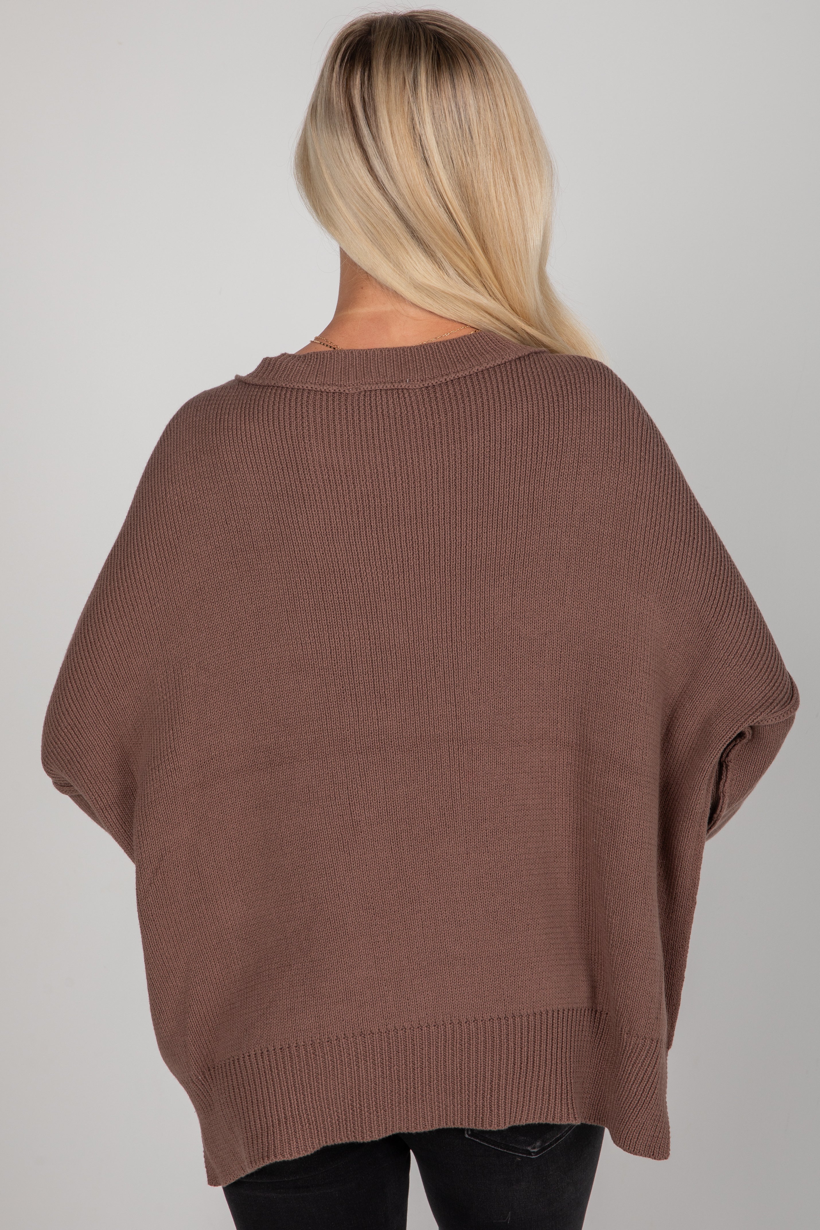 Brown sweater worn by a person on a plain background