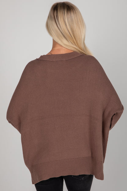 Brown sweater worn by a person on a plain background