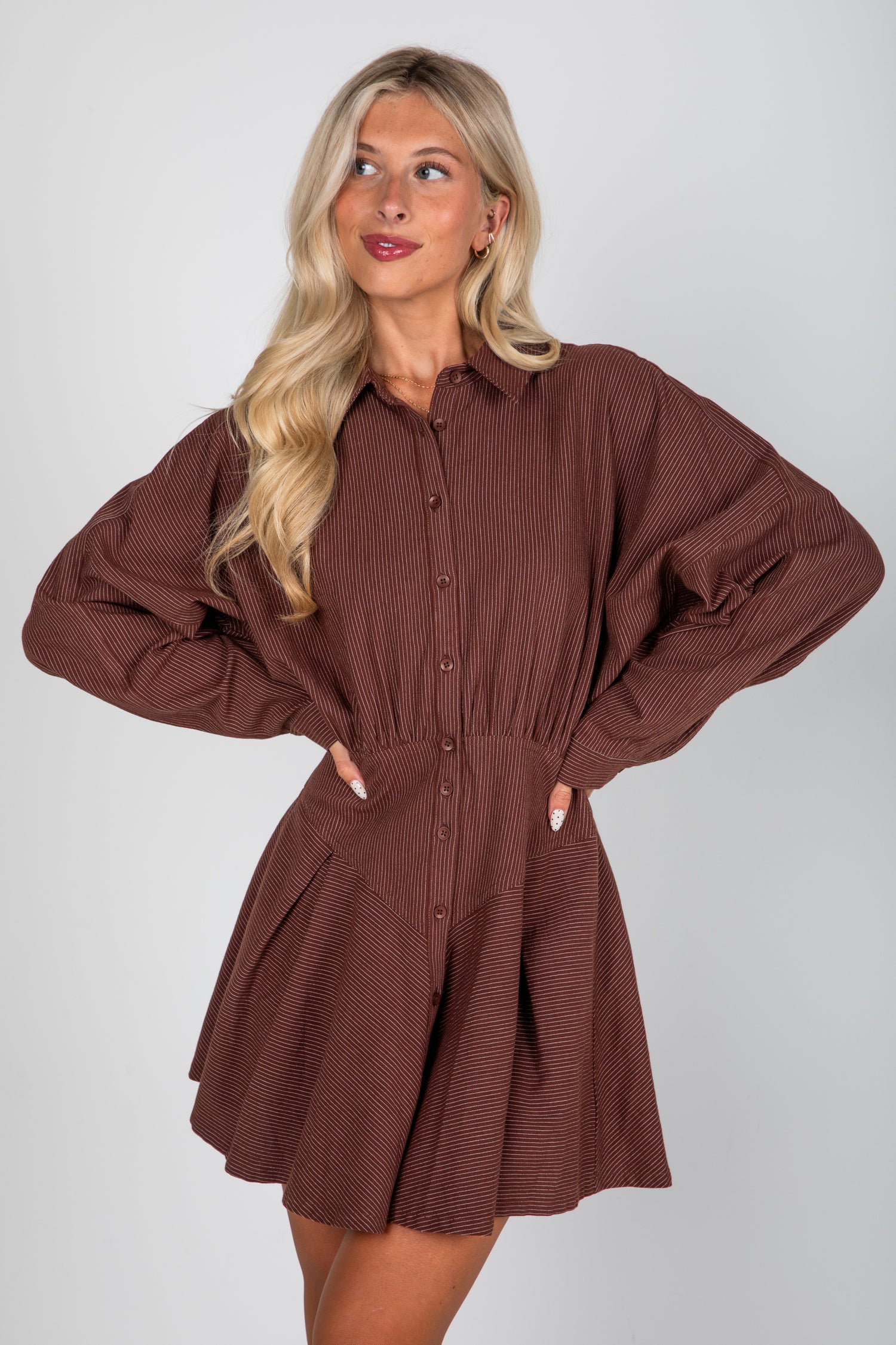 Woman wearing a brown ribbed dress against a white background
