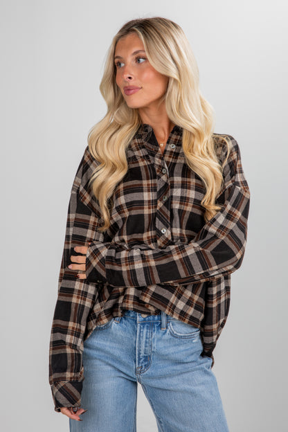 Woman wearing a plaid shirt and jeans against a plain background