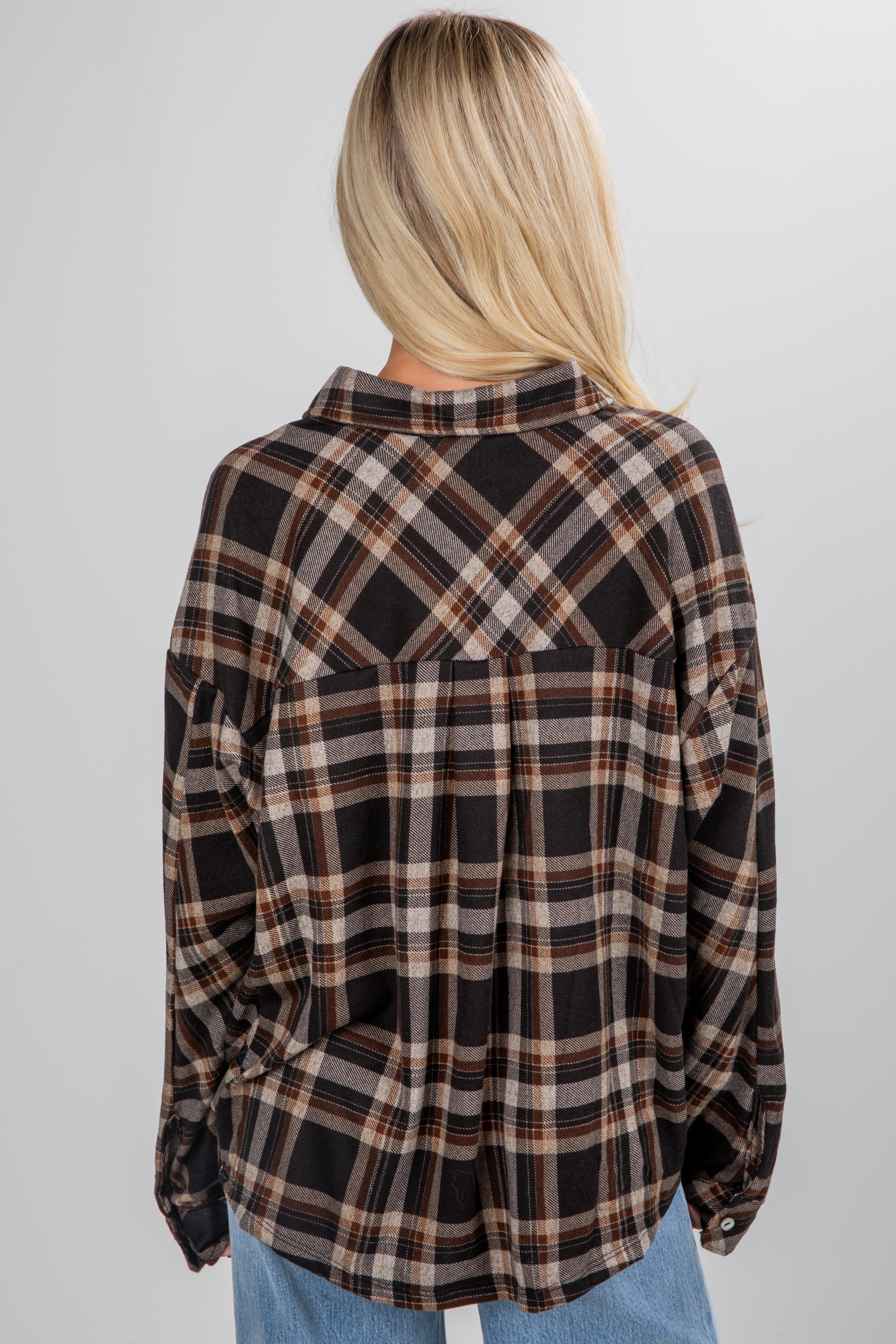 Person wearing a plaid shirt with a neutral background