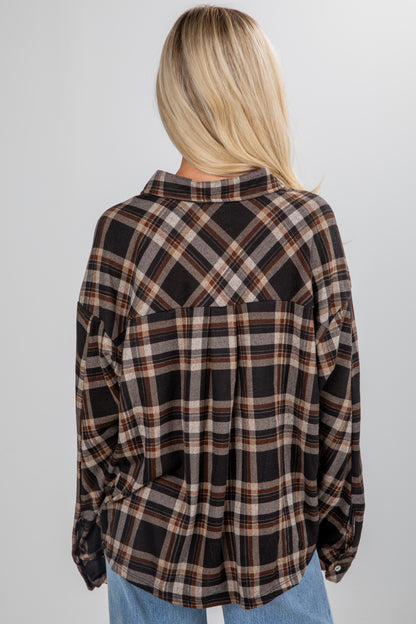 Person wearing a plaid shirt with a neutral background