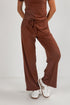Brown jumpsuit worn by a person on a white background