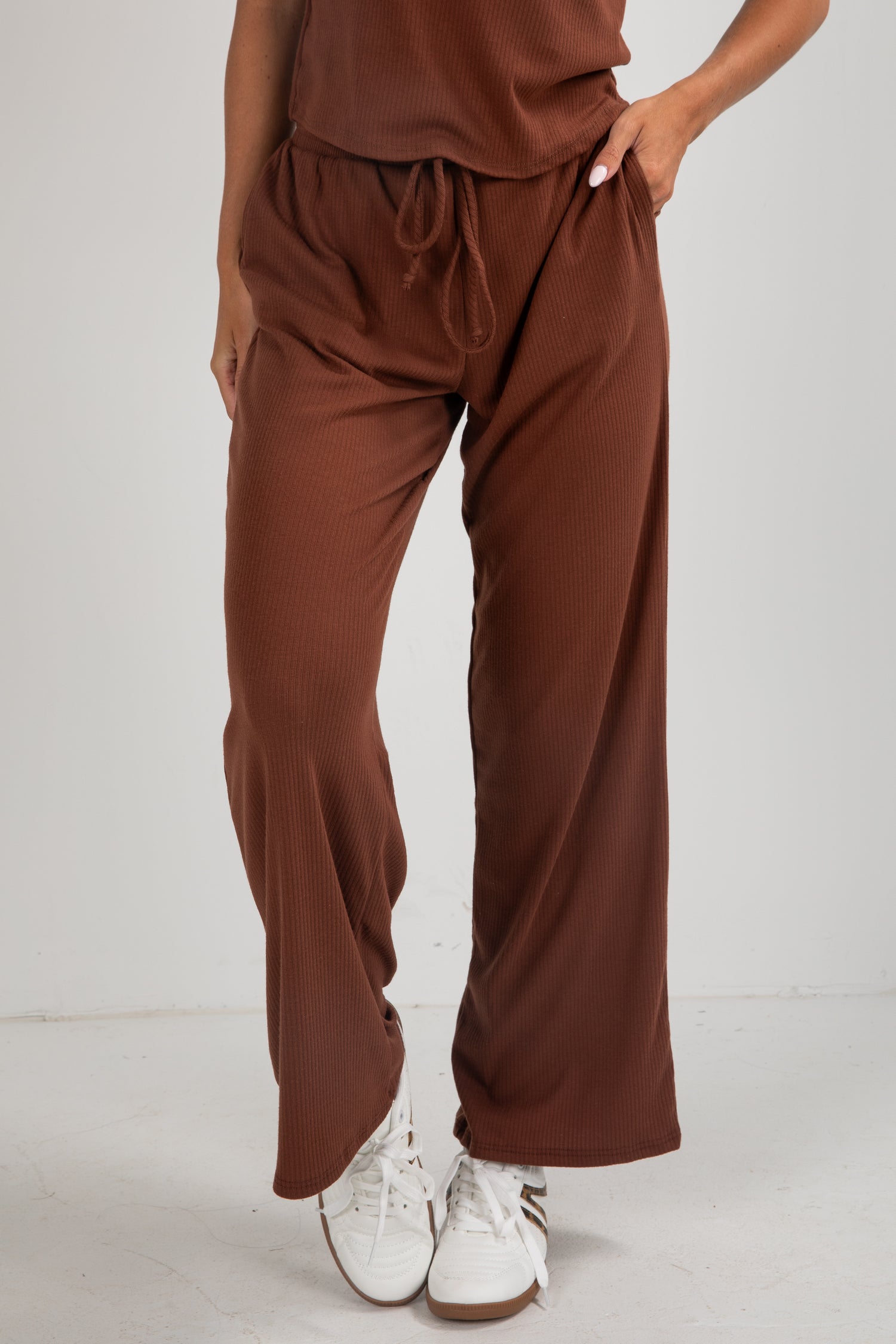 Brown pants worn by a person on a white background
