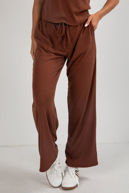 Brown pants worn by a person on a white background