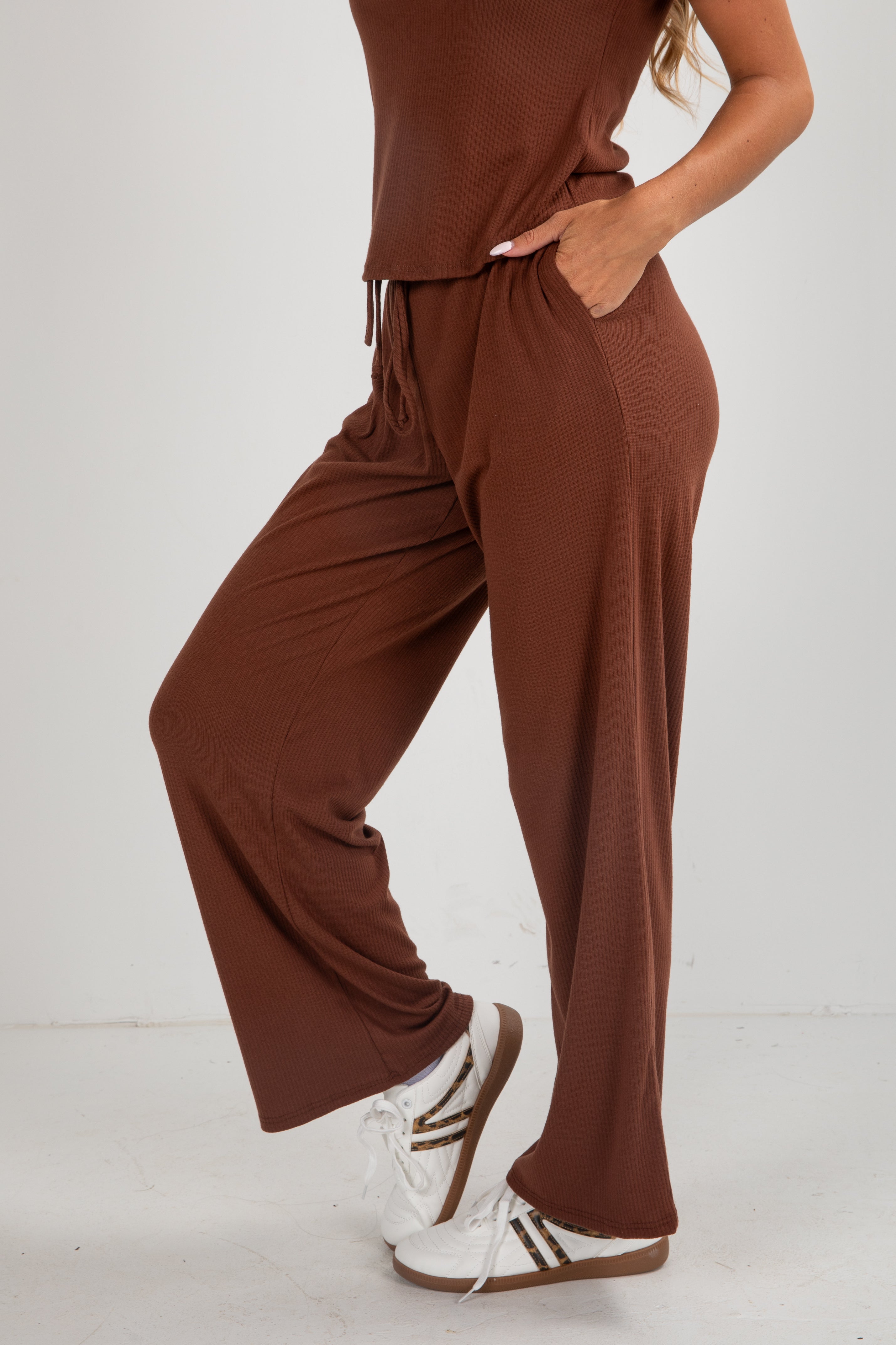 Brown jumpsuit worn by a person on a white background