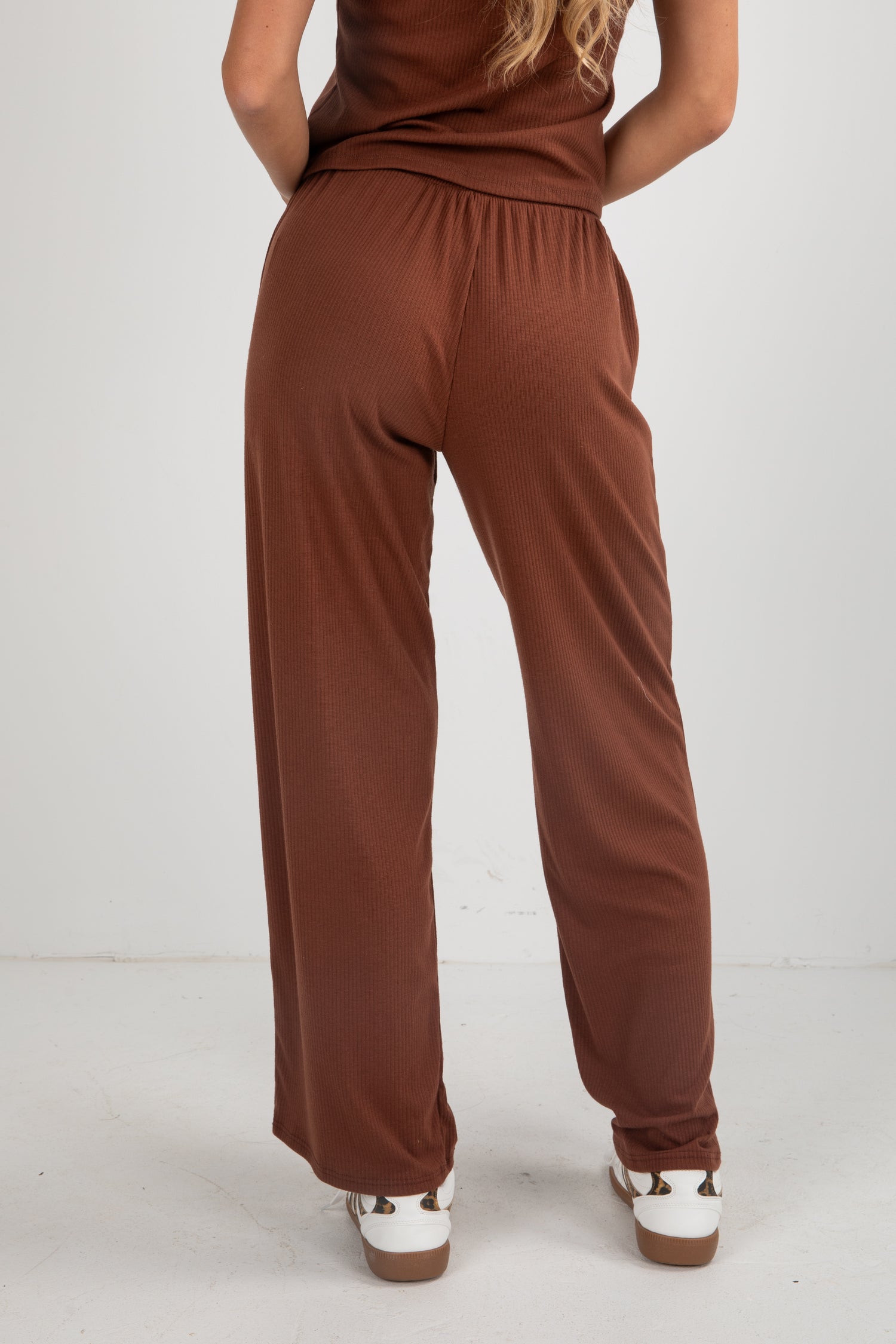 Brown jumpsuit worn by a person on a white background
