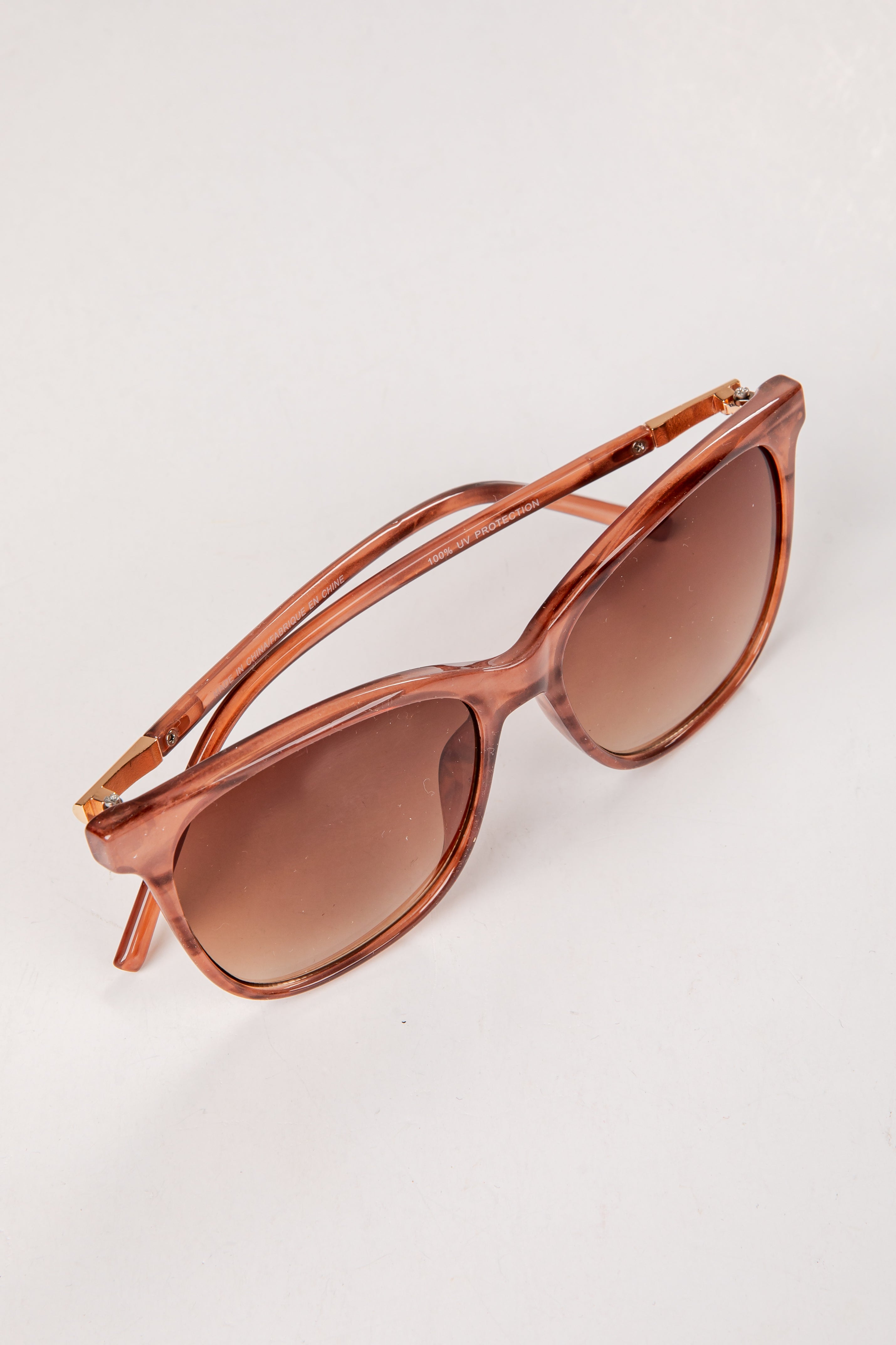 Sunglasses with brown frame and lenses on a white background