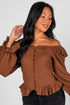Woman wearing a brown off-shoulder blouse with ruffled details on a white background
