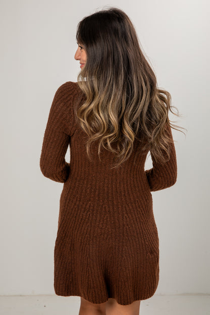 Woman wearing a brown knitted dress against a white background