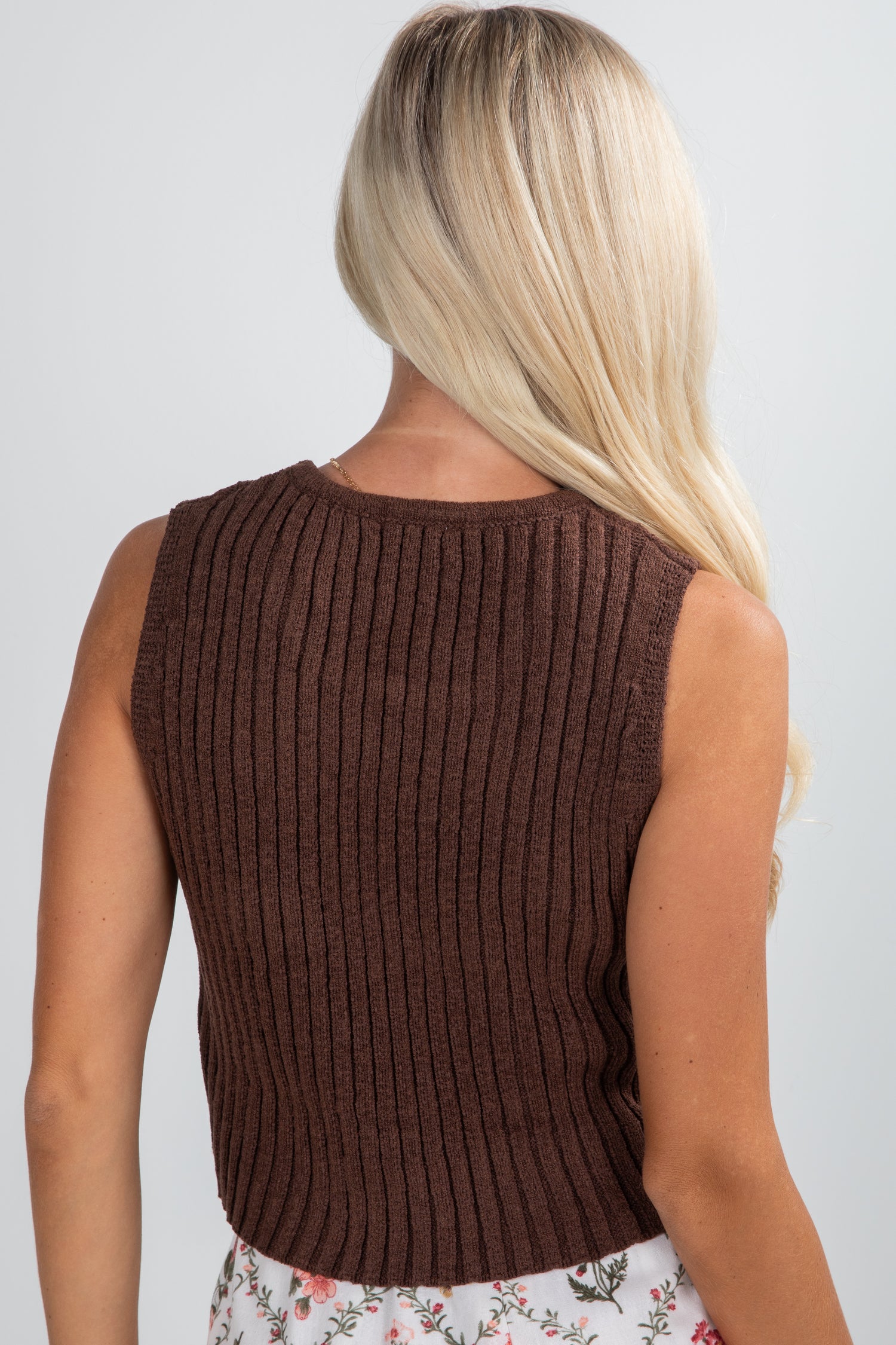 Brown ribbed sleeveless top worn by a person on a plain background